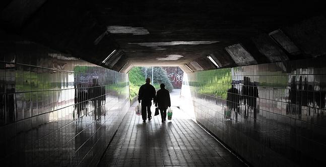 Dos viandantes pasan por uno de los túneles de Lutxana./ J. Alemany