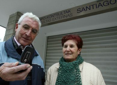 AVISO. Dos usuarios del hospital Santiago revisan su teléfono móvil a las puertas del centro sanitario. / IGOR AIZPURU