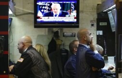 Un grupo de 'brokers' trabaja mientras Henry Paulson comparece en una rueda de prensa. / REUTERS
