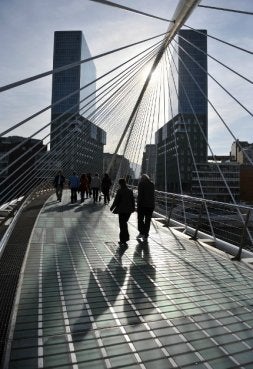 Paseantes cruzan ayer la pasarela bajo los últimos rayos de la tarde. / FERNANDO GÓMEZ