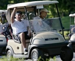 Obama conduce un carrito de golf entre hoyo y hoyo del recorrido con Biden. / AP