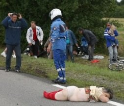 Una espectadora herida yace sobre el asfalto. / AFP