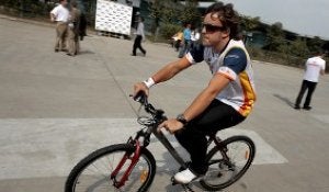 Fernando Alonso pasea en bicicleta por un circuito.