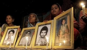 Familiares de víctimas de la catástrofe muestran fotos de fallecidos durante una vigilia en Bhopal. ::
EFE