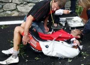 Óscar Pereiro es atendido tras caerse en el col del Agnello, durante el Tour 2008. ::                             EFE
