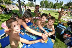 Entre baño y baño los más pequeños se entretienen jugando con el Trivial que han pedido en la bibliopiscina. ::
AVELINO GÓMEZ