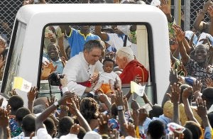 El Papa bendice a un niño en su camino hacia el estadio donde se celebró la misa. ::                         REUTERS