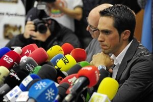 Alberto Contador, con gesto serio, ofrece sus impresiones acompañado de Bjarne Riis. ::                         EFE