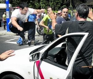 Un grupo de manifestantes ataca el taxi de un compañero que no secundó la marcha. ::                         EFE