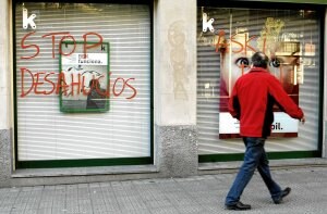 Varias oficinas de entidades financieras amanecieron ayer con pintadas. En la imagen, una sucursal de Kutxabank en el barrio bilbaíno de Deusto. ::                         EFE