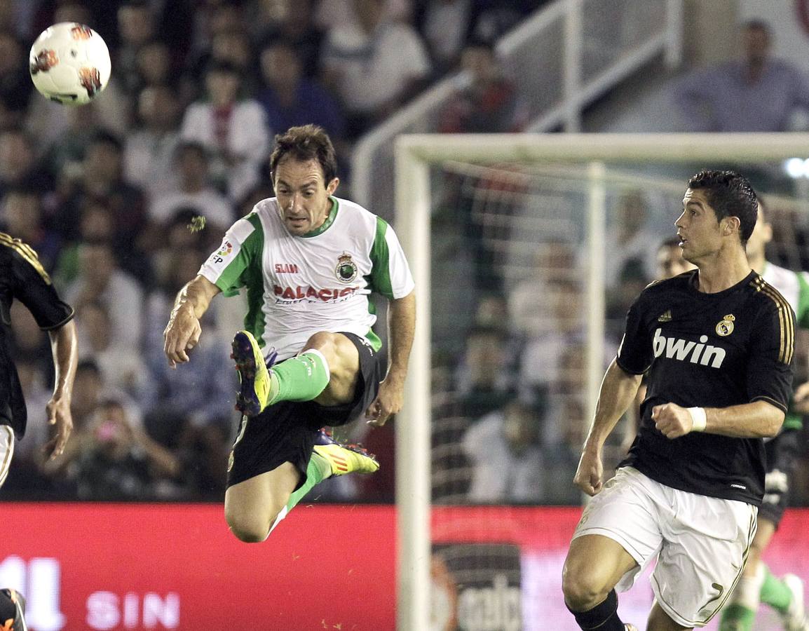 El delantero del Racing de Santander, Pedro Munitis despeja un balón ante el delantero del Real Madrid, Cristiano Ronaldo