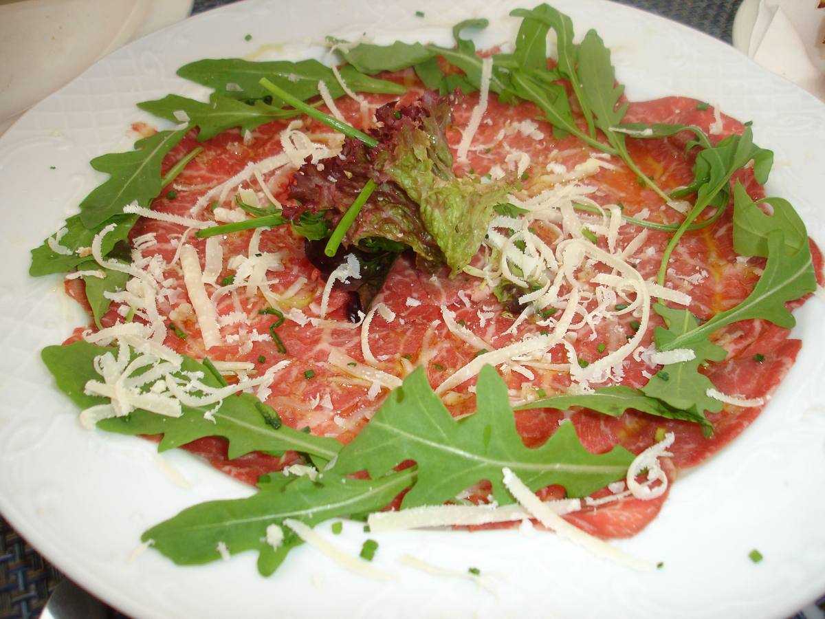 Carpaccio /Steak tartar. Es creciente el consumo de carnes crudas. El carpaccio son finísimas láminas de carne cruda que se aderezan generalmente con un aceite, zumo de limón y pimienta. El steak tartar es otro modo de tomar carne cruda, pero a partir de una receta con numerosos ingredientes. Trucos:En el caso del carpaccio que esté cortado muy fino y en el caso del steak tartar, la carne debe estar cortada a cuchillo, no a máquina. Guarniciones:Al carpaccio le va bien un buen aceite de oliva virgen y un auténtico queso parmesano italiano. Del steak tartar, ver artículo en páginas siguientes.