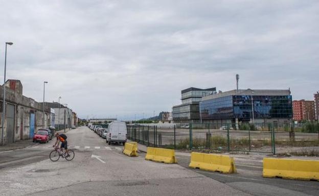 Un ciclista circula por la carretera que rodea los terrenos de Varadero en los que se realizará la intervención municipal. 