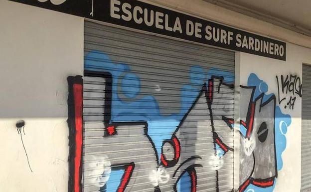 Una de las pintadas en una persiana de los negocios que hay en los bajos de la playa.