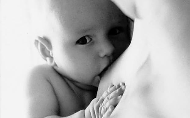 Bebé mamando del pecho de su madre. 