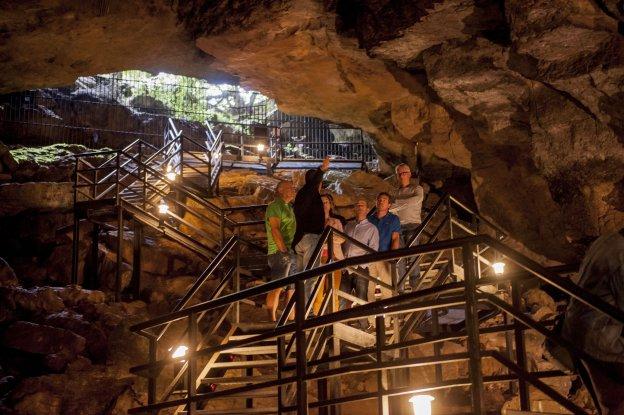 Un grupo de visitantes accede a la cueva a través de la escalinata