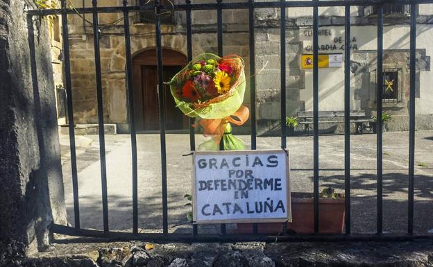 El ramo de flores y el cartel encontrados el sábado en el cuartel de Bádames (Voto).