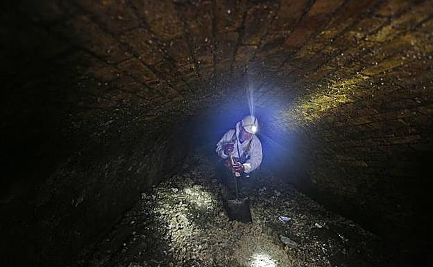 Atasco. Un operario observa la masa de toallitas extraida de un colector en San Sebastián este verano