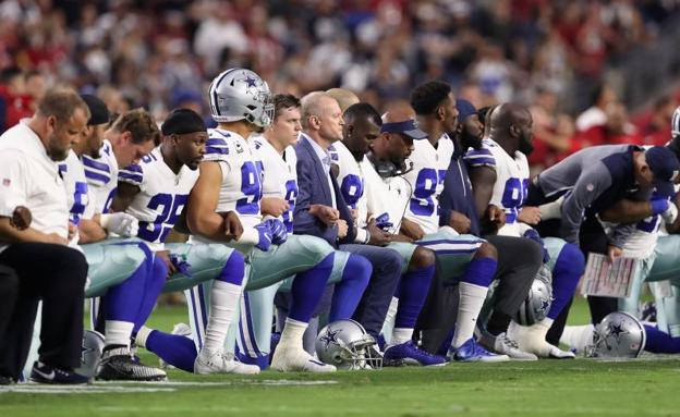 Miembros de los Dallas Cowboys arrodillados antes del partido ante los Cardinals. 