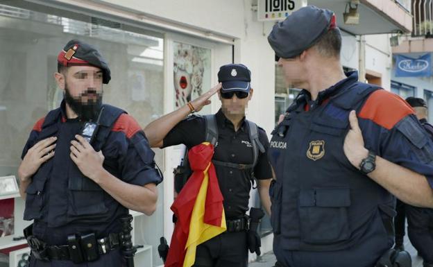Un policía nacional, entre dos Mossos de Escuadra. 