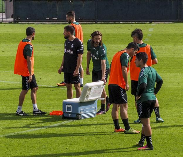 Gonzalo, junto a la nevera, se hidrata junto a otros compañeros.