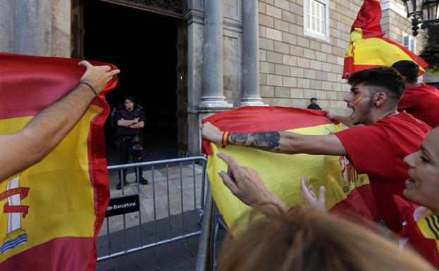 Un grupo de personas increpa a los Mossos d'Esquadra en la puerta del Palau de la Generalitat . 