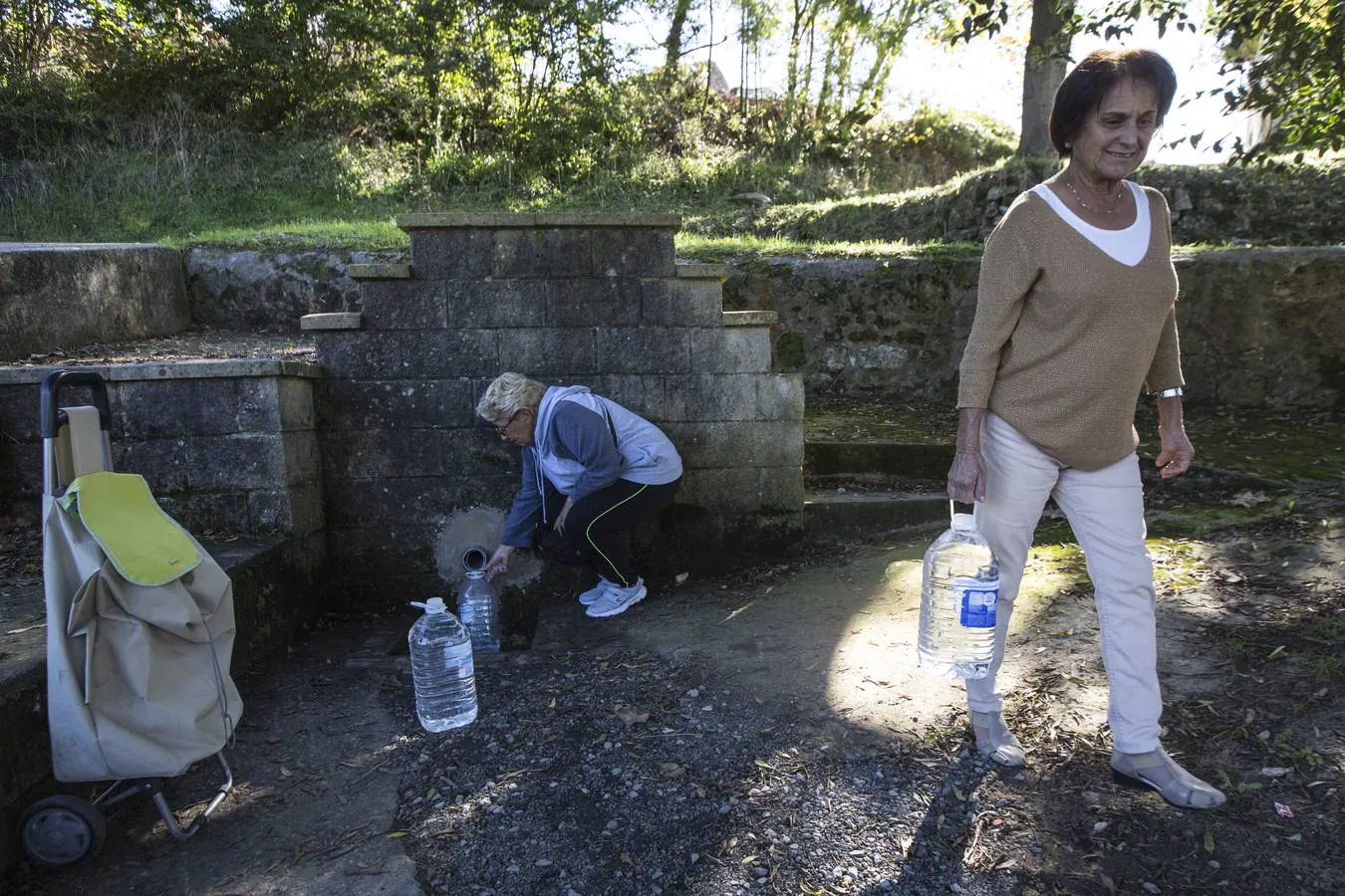 Maribel Lledías y María Rivas se encontraron ayer llenando garrafas en la fuente de Los Corrales.