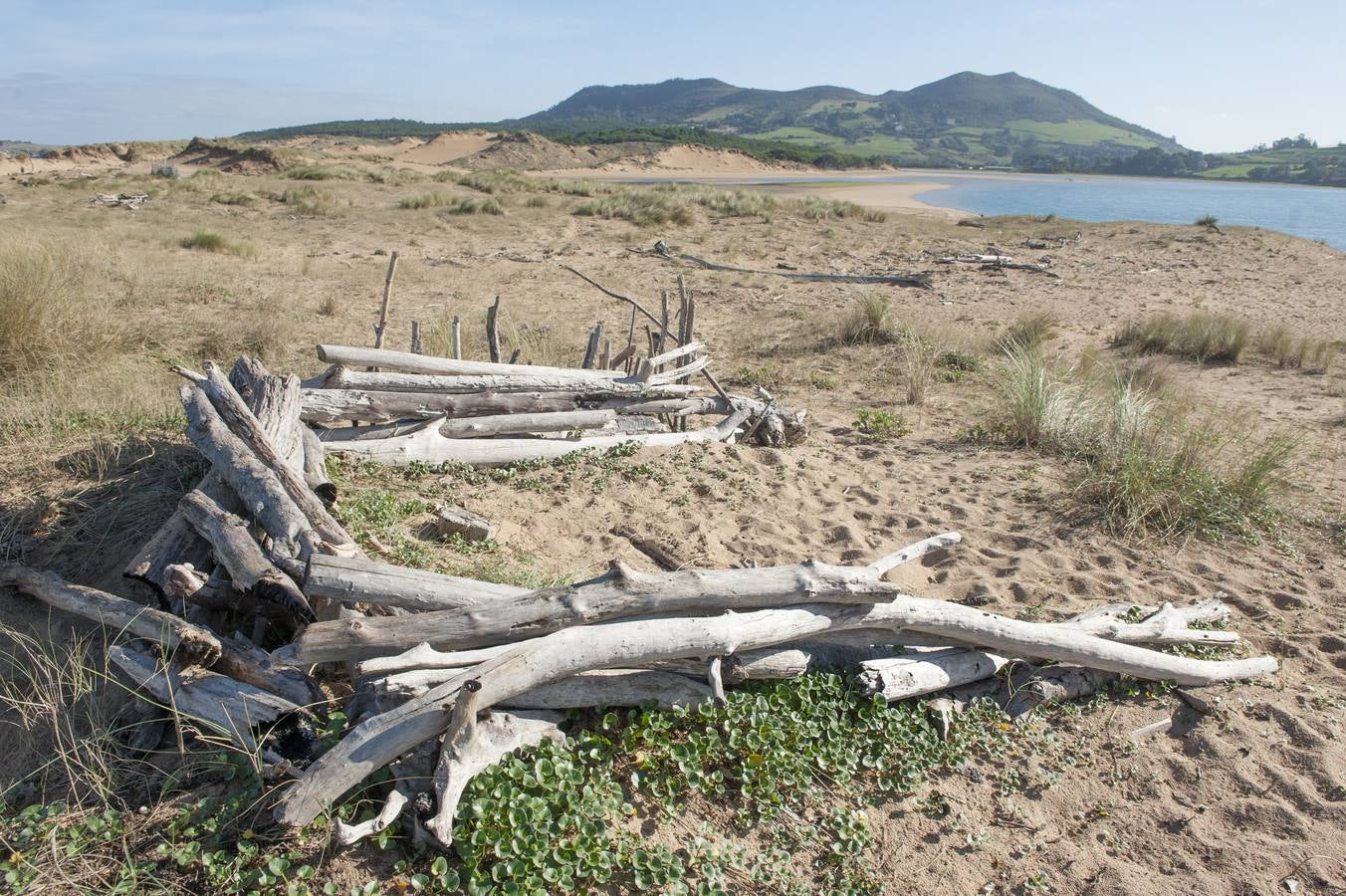 El tramo final de Valdearenas (Liencres) se llena de casetas y esculturas hechas de lo que trae el mar