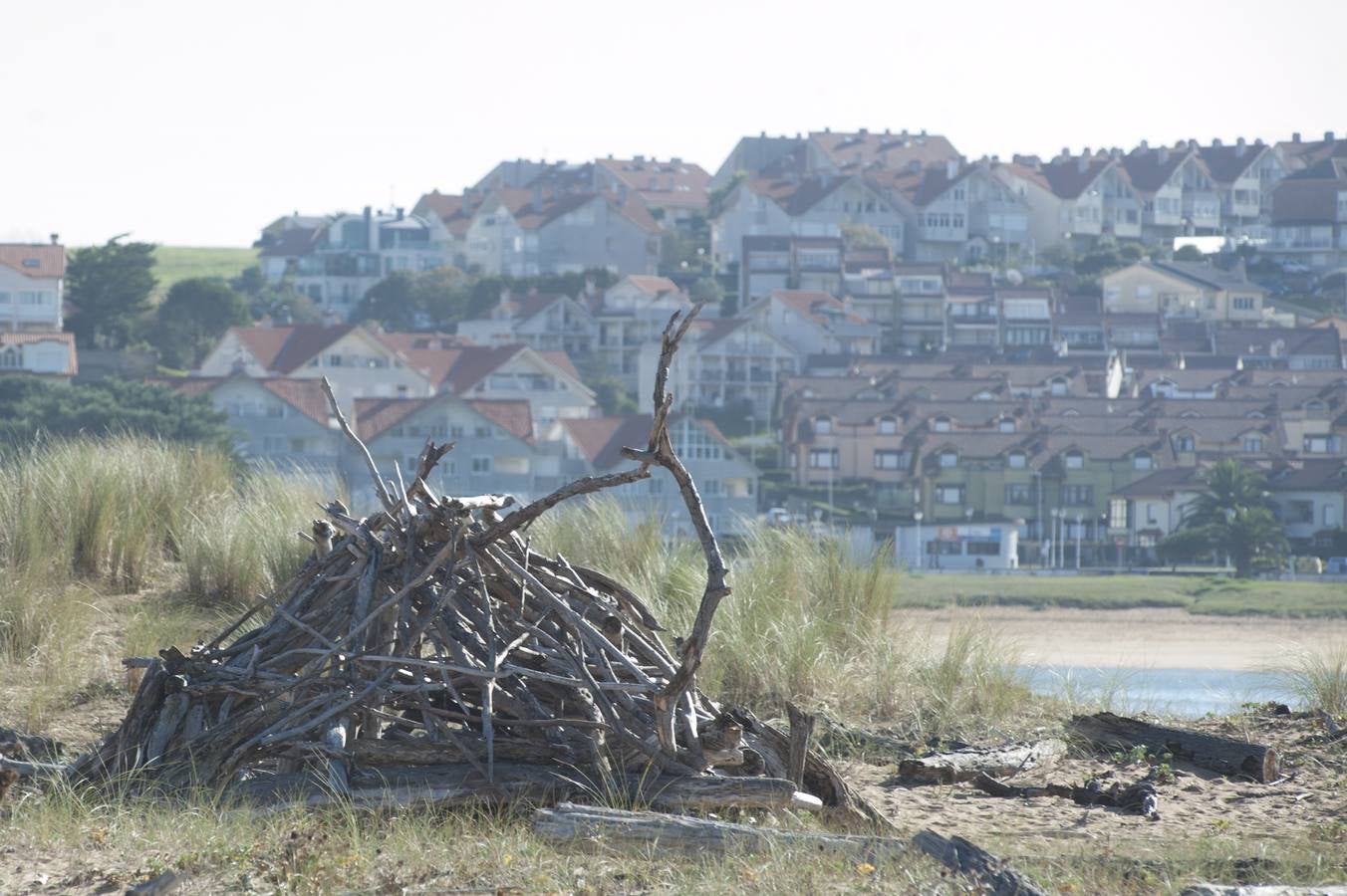 El tramo final de Valdearenas (Liencres) se llena de casetas y esculturas hechas de lo que trae el mar