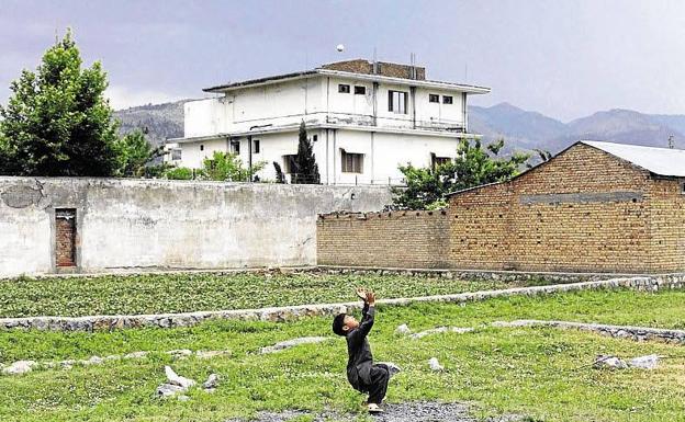 Un niño juega frente a la casa donde murió Bin Laden.