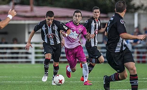 Tirado, del Escobedo, conduce el balón ante la presión de Perri, de la Gimnástica 