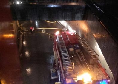 Imagen secundaria 1 - Imágenes de la serrería desplomada y de los bomberos achicando el agua del túnel de la estación de Los Corrales de Buelna.