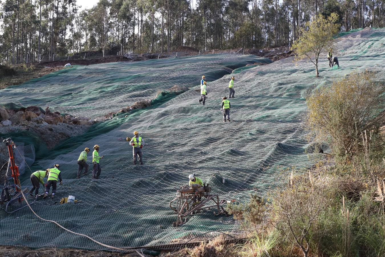 Las máquinas y el personal trabajan para despejar los dos carriles cortados por un argayo a la altura de Caviedes