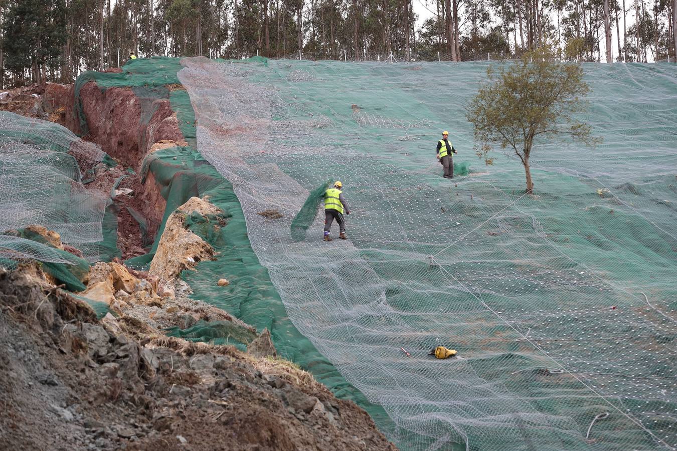 Las máquinas y el personal trabajan para despejar los dos carriles cortados por un argayo a la altura de Caviedes