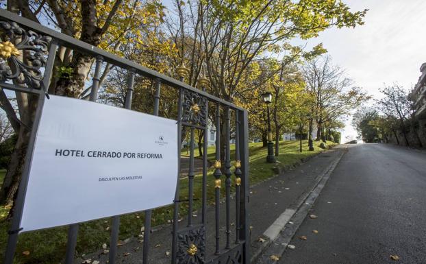 Un cartel y una cadena avisan a los paseantes de que el hotel está cerrado por ahora. 