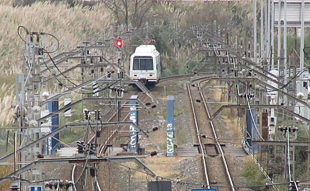 Uno de los trenes averiados de FEVE, parado junto al puente de la ría de Boo 