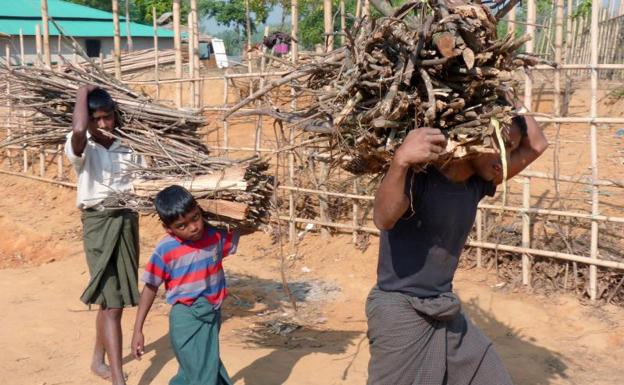 Dos niños acompañan a un adulto en el campamento de Kutupalong, en Bangladesh, donde se asientan muchos de los rohinyás que han huido de Birmania.