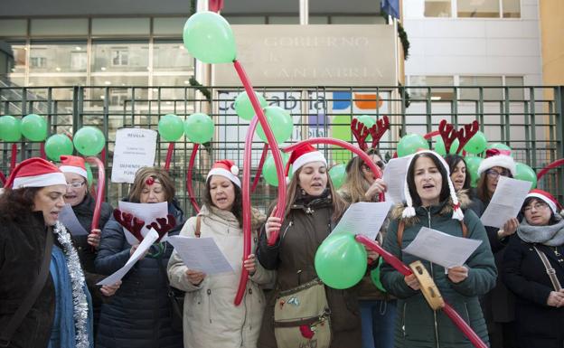 Las profesionales del CAD de Sierrallana han protestado ante la sede del Gobierno cantando villancicos.