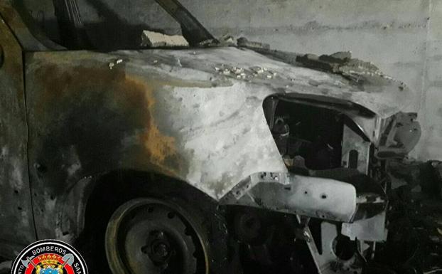 Imagen principal - Dos coches y un ciclomotor se queman en un incendio de un garaje comunitario en Cazoña