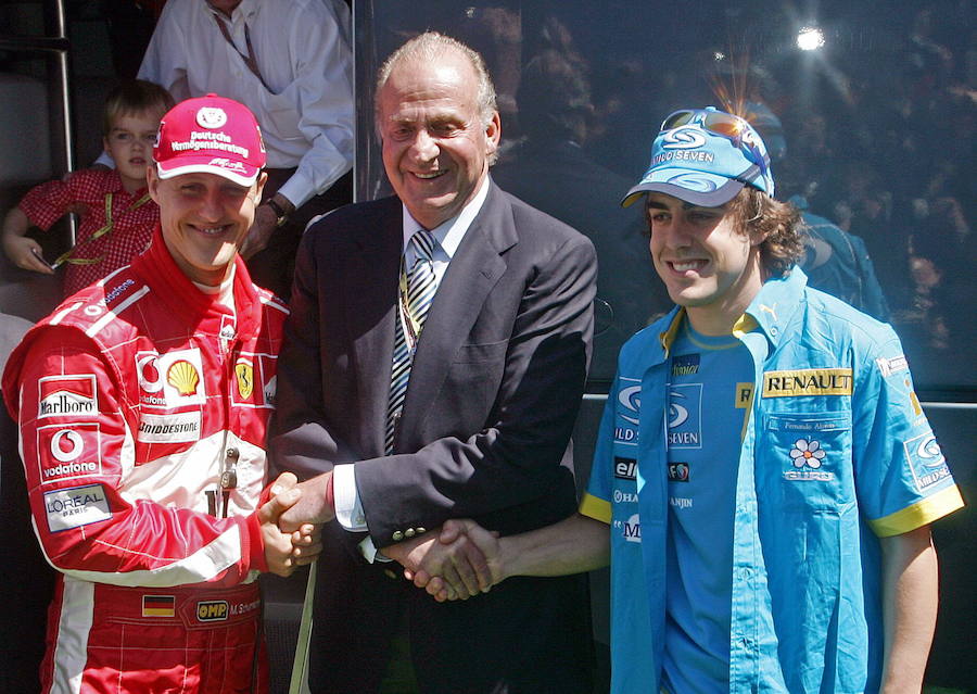 Juan Carlos I, Rey de España, posa estrechando las manos de los pilotos de Formula Uno, el alemán Michael Schumacher y el español Fernando Alonso, durante el Gran Premio de España de Montmeló en 2005. Barcelona
