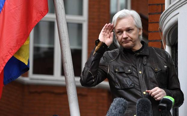 Assange saluda desde la entrada de la embajada de Ecuador. 