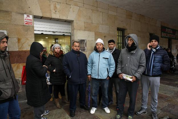 Vecinos que se quedaron sin ayudas en la última convocatoria esperan junto a la oficina de Servicios Sociales. :: LUIS PALOMEQUE