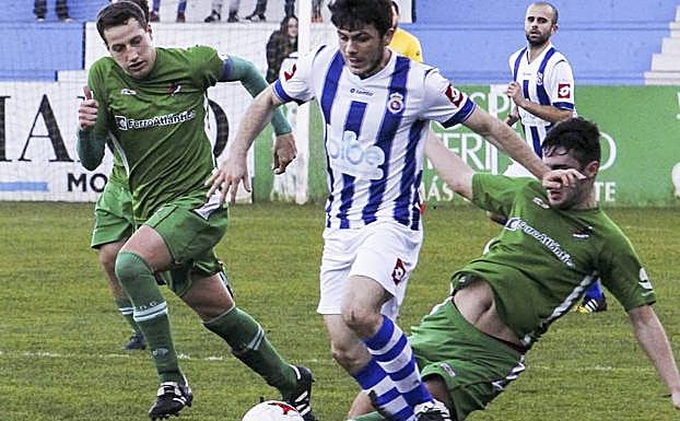 El gimnástico Cote conduce el balón ante la presión de dos rivales. :