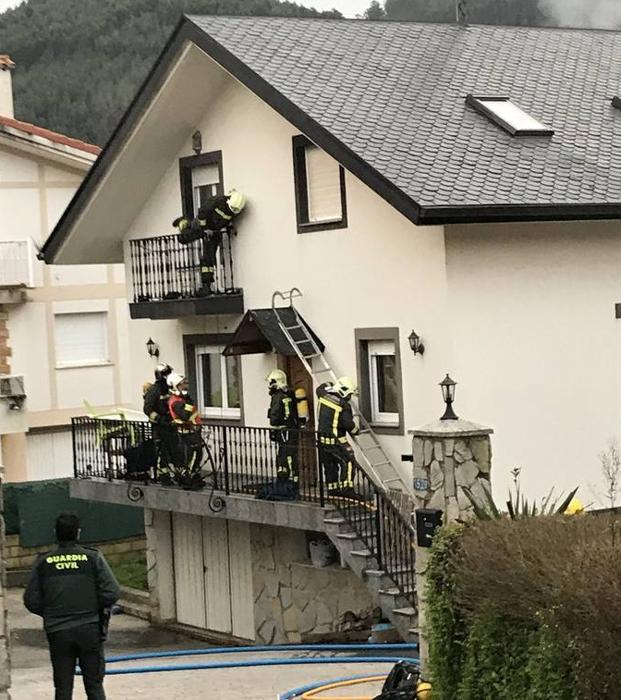 Los bomberos de Castro, con la escalera manual que emplearon para rescatar a las personas confinadas en el balcón.