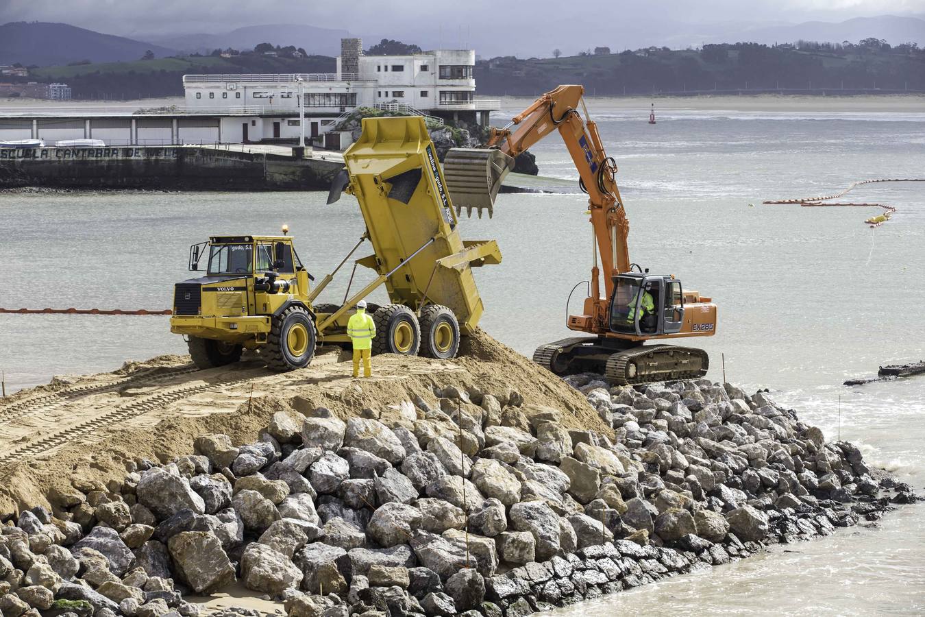 El primer dique para contener la arena ya asoma de forma evidente en La Magdalena.Con la playa cortada y la marea baja, la pala da forma al primero de los espigones, que llama la atención de los curiosos que se acercan a verlo 