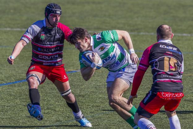 Lautaro Lualdi lleva el oval ante dos jugadores del Hernani en el encuentro de ayer en San Román. 