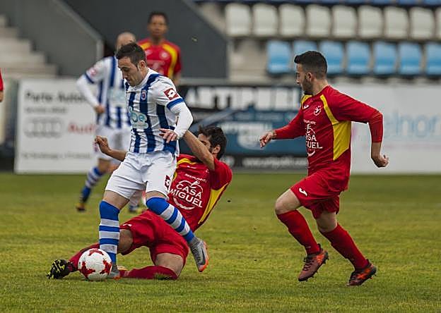 El gimnástico Perry recibe una entrada de un rival mientras conduce el balón.