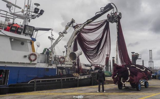 Un barco prepara las redes en el puerto de Colindres. 