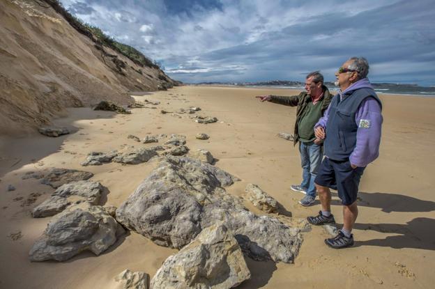 La pérdida de arena en la playa de Loredo deja ver las piedras del antiguo acantilado, antes cubierto por la duna.