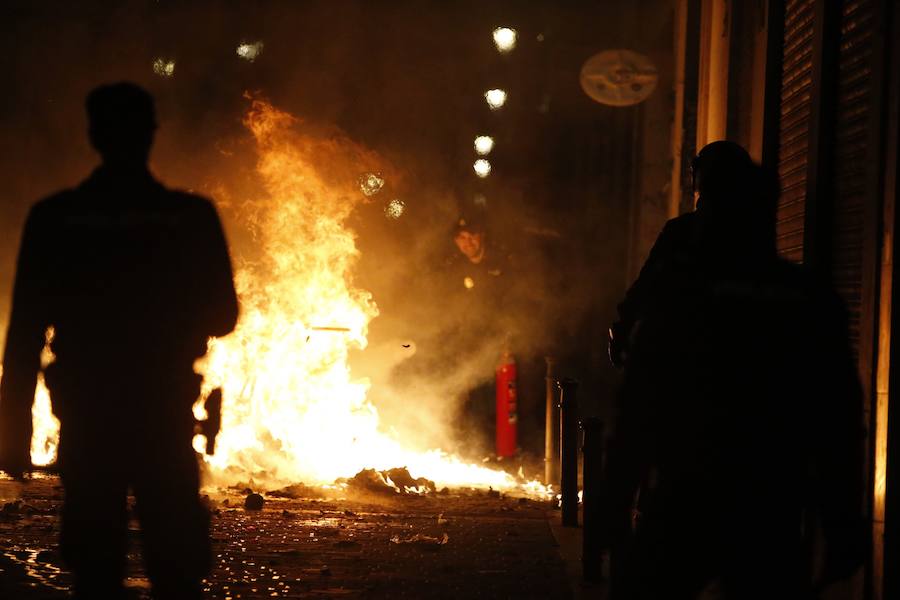 Un grupo de más de medio centenar de personas han quemado contenedores y causado desperfectos en el mobiliario urbano en el madrileño barrio de Lavapiés tras la muerte este jueves de un mantero de 35 años y origen subsahariano a causa de una parada cardiorrespiratoria.